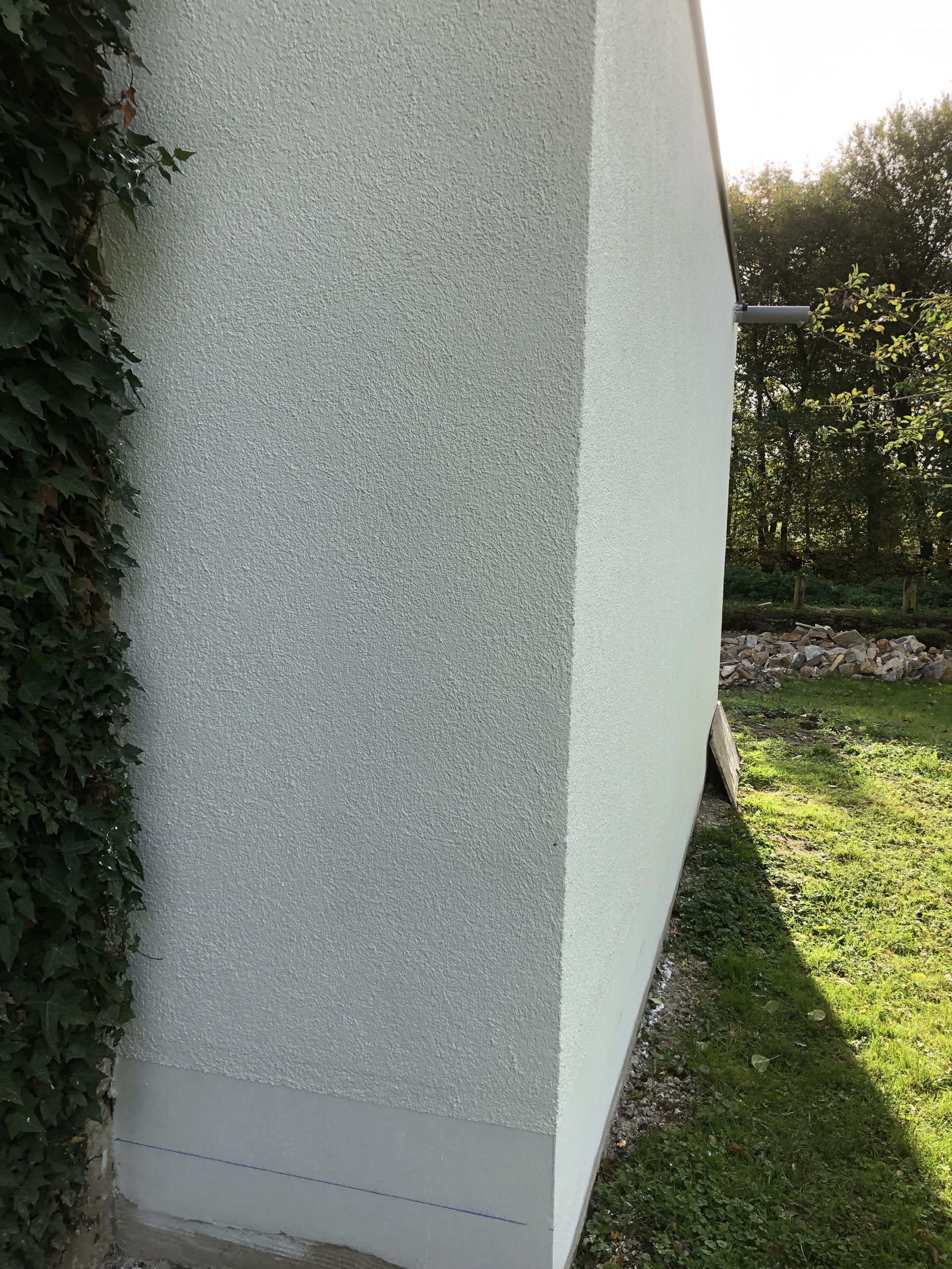 Außenecke eines Gebäudes mit neu ausgeführtem Fassaden- und Sockelputz