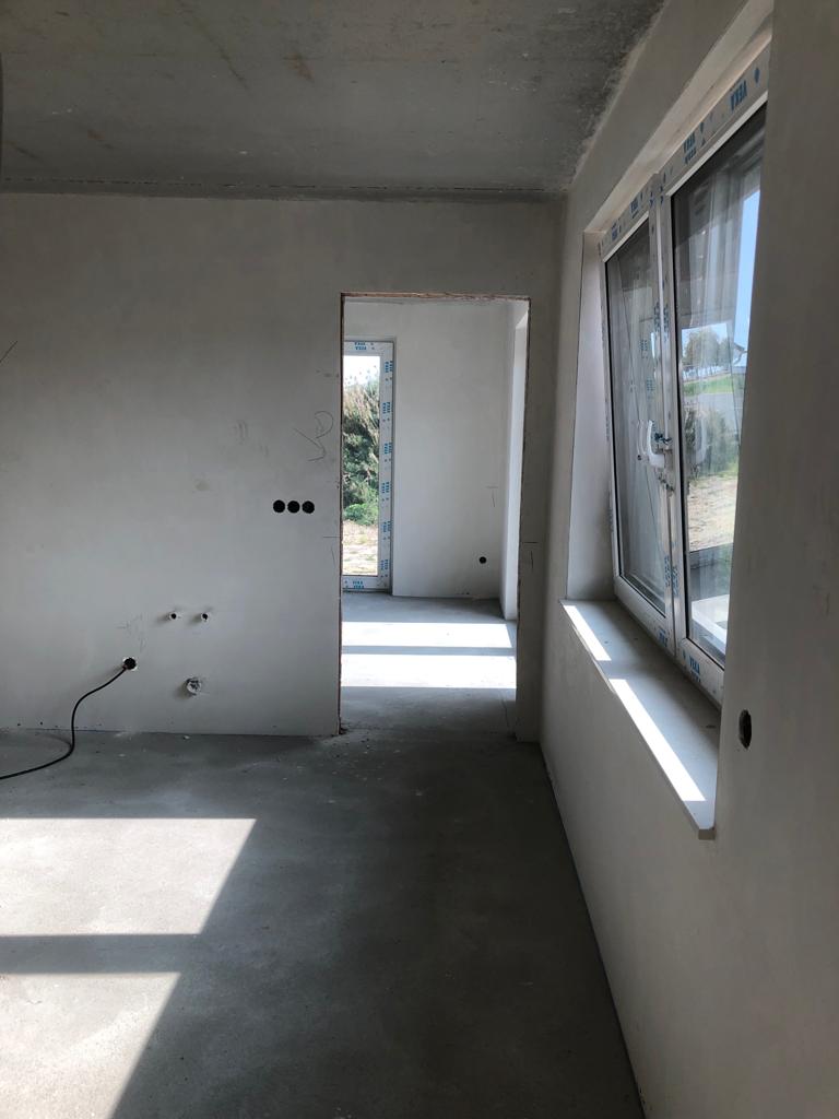 Heller Wohnraum mit frisch ausgeführtem Innenputz und großen Fensterflächen