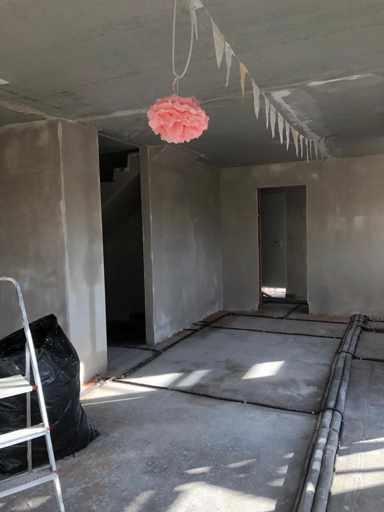 Innenausbau im Neubau während der Bauphase mit frisch verputzten Wänden