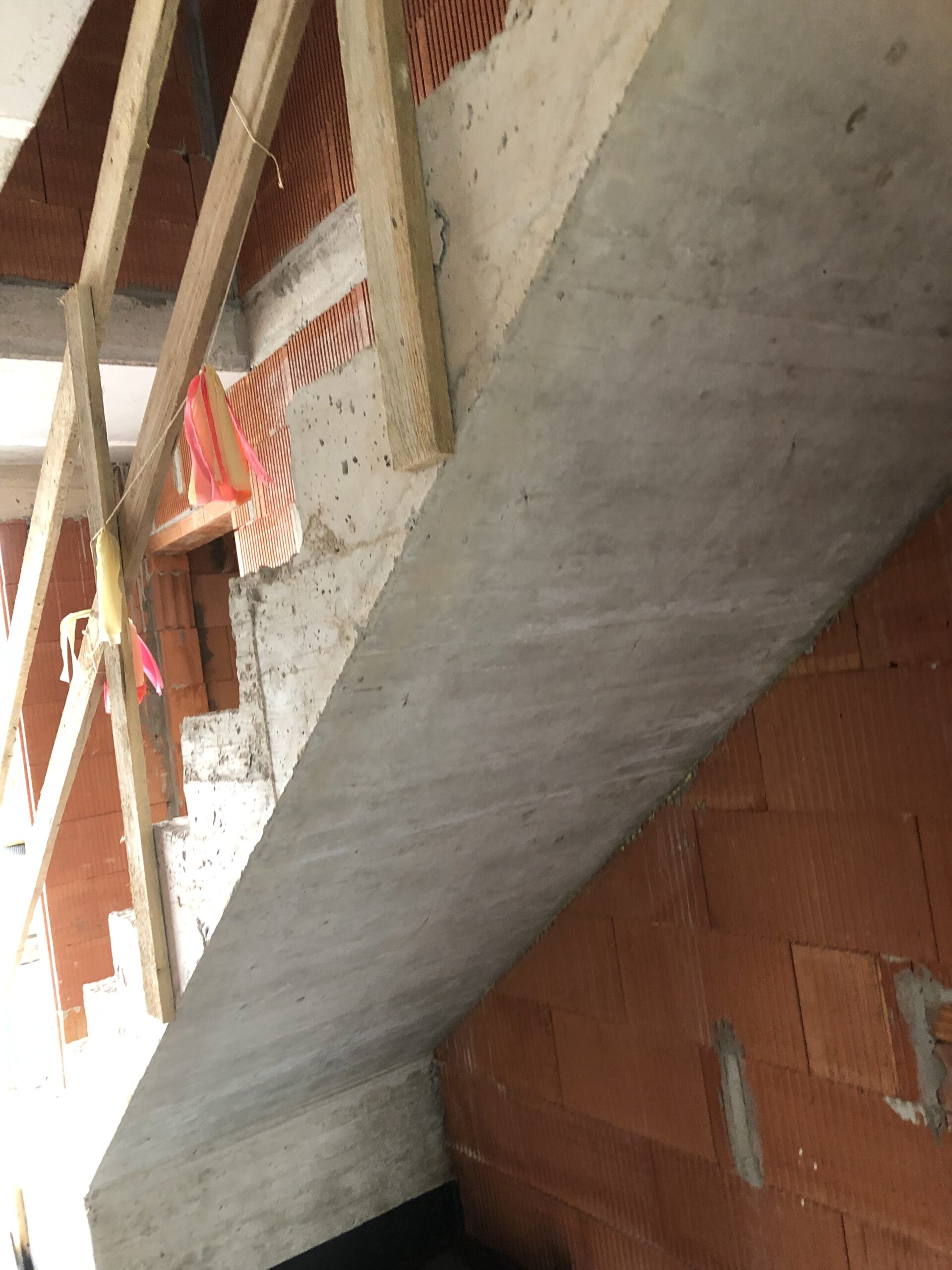 Treppenhaus im Rohbau mit unverputzten Wänden vor den Innenputzarbeiten